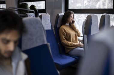 young-woman-talking-her-smartphone-while-traveling-by-train